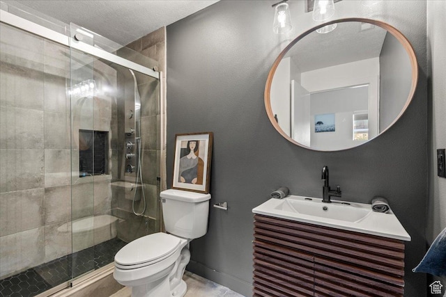full bathroom featuring toilet, a stall shower, a textured ceiling, and vanity