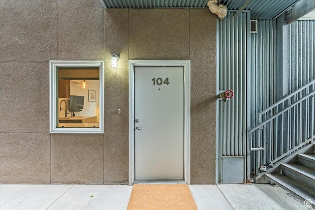 doorway to property featuring stucco siding
