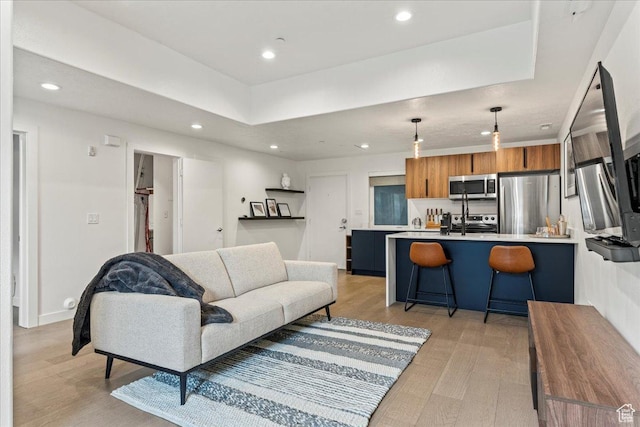 living area featuring light wood-style flooring, baseboards, and recessed lighting