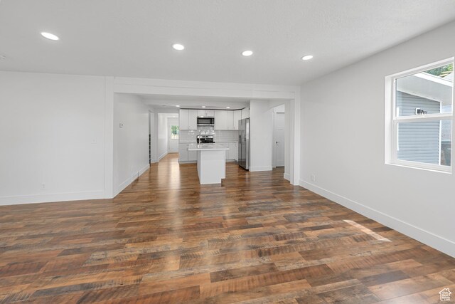 524 N 200 W, Tooele, UT 84074 - unfurnished living room with dark wood-style floors and recessed lighting