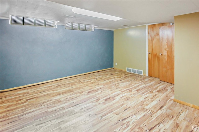 finished basement with wood finished floors, visible vents, and baseboards