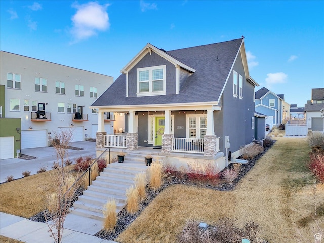 view of front of property featuring stairs, a porch, roof with shingles, and stucco siding