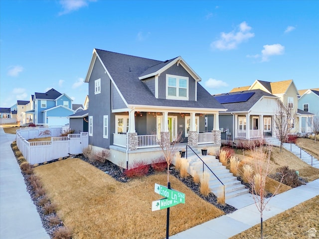 view of front of property featuring covered porch, a residential view, and fence