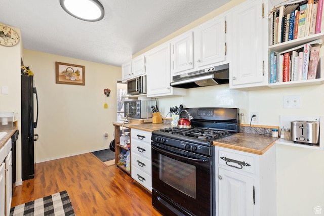 879 E Main St, Mount Pleasant, UT 84647 - kitchen featuring under cabinet range hood, dark wood-style flooring, white cabinetry, baseboards, and black appliances