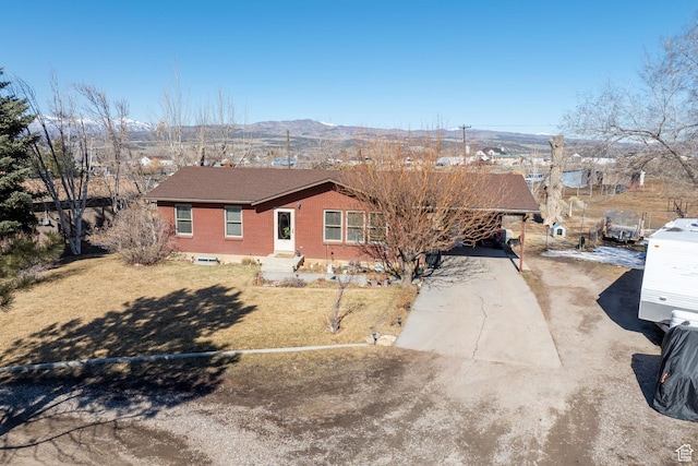 879 E Main St, Mount Pleasant, UT 84647 - ranch-style house featuring brick siding, dirt driveway, a front yard, a mountain view, and an attached carport
