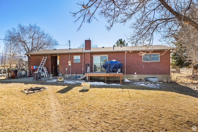 879 E Main St, Mount Pleasant, UT 84647 - rear view of house with brick siding, a chimney, a wooden deck, and a lawn
