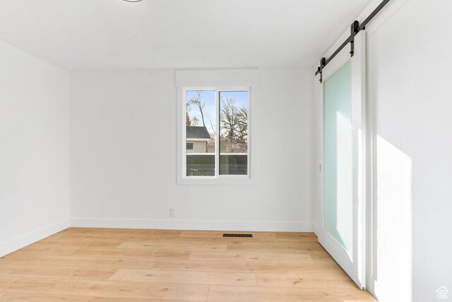 1379 E Sumac Way, Murray, UT 84121 - spare room featuring a barn door, light wood-style flooring, and baseboards