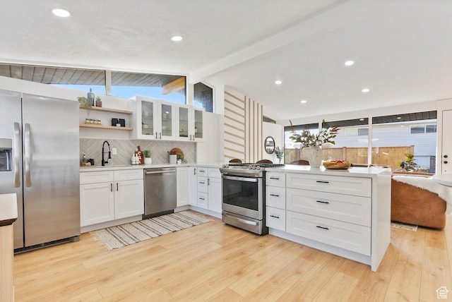1379 E Sumac Way, Murray, UT 84121 - kitchen with appliances with stainless steel finishes, a peninsula, a sink, backsplash, and white cabinetry