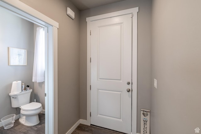 bathroom with toilet and baseboards