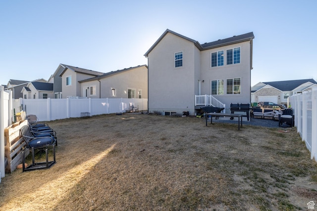 back of property with a yard, a fenced backyard, and stucco siding