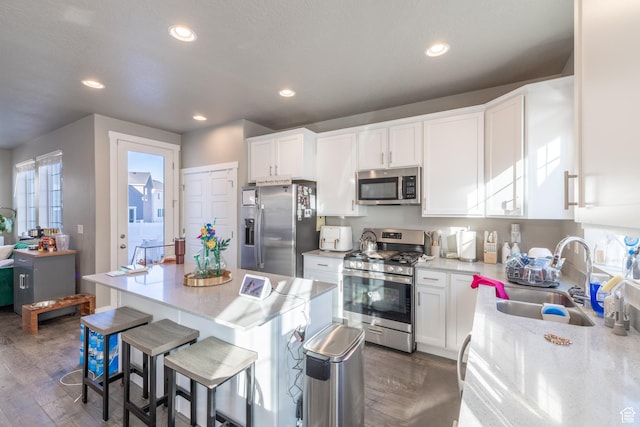 kitchen featuring dark wood-type flooring, white cabinetry, stainless steel appliances, and a sink