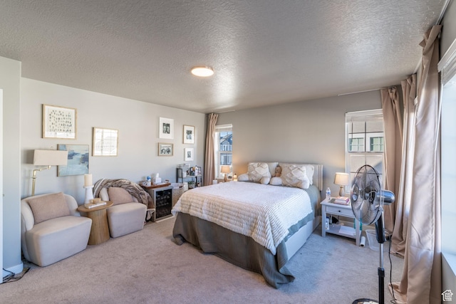 bedroom featuring carpet floors, multiple windows, and a textured ceiling