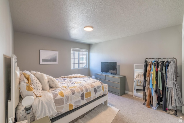 bedroom featuring baseboards, a textured ceiling, and light colored carpet