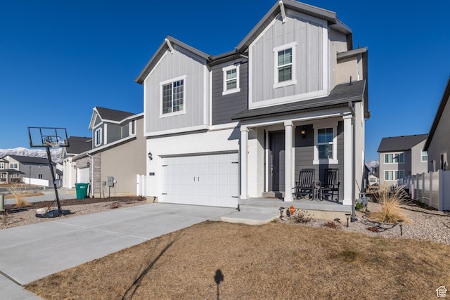 view of front facade with an attached garage, covered porch, a residential view, and board and batten siding