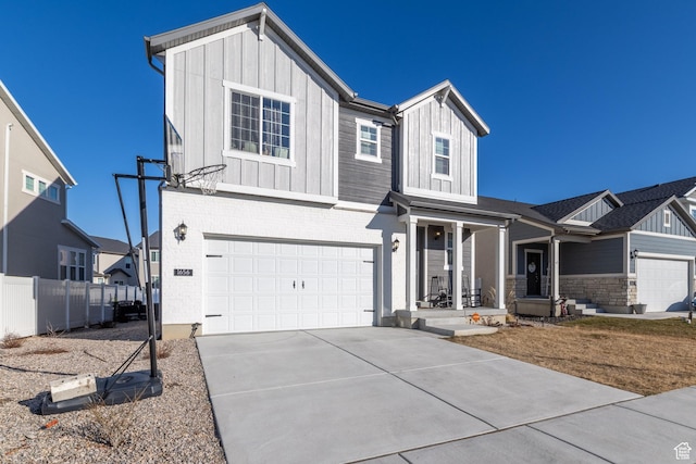modern inspired farmhouse featuring a porch, a garage, fence, concrete driveway, and board and batten siding