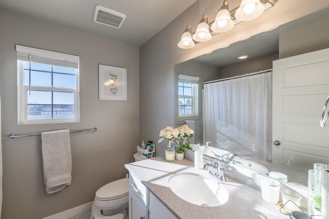 bathroom with curtained shower, toilet, vanity, visible vents, and baseboards