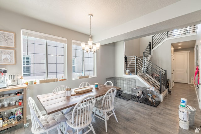 dining area with a chandelier, stairway, a textured ceiling, and wood finished floors