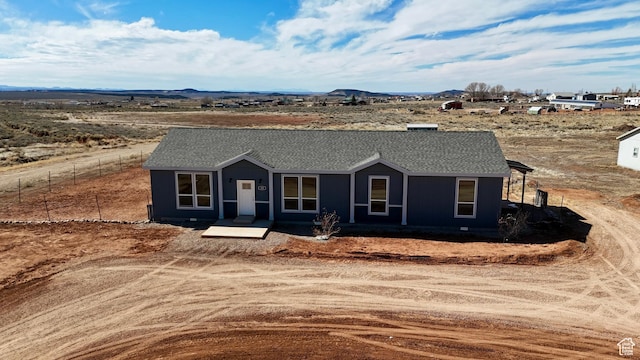view of front facade featuring roof with shingles, fence, and a mountain view