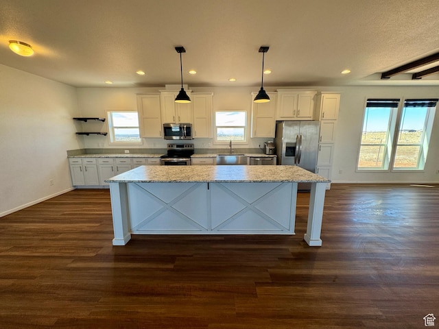 kitchen with stainless steel appliances, dark wood-style flooring, white cabinetry, a wealth of natural light, and a center island