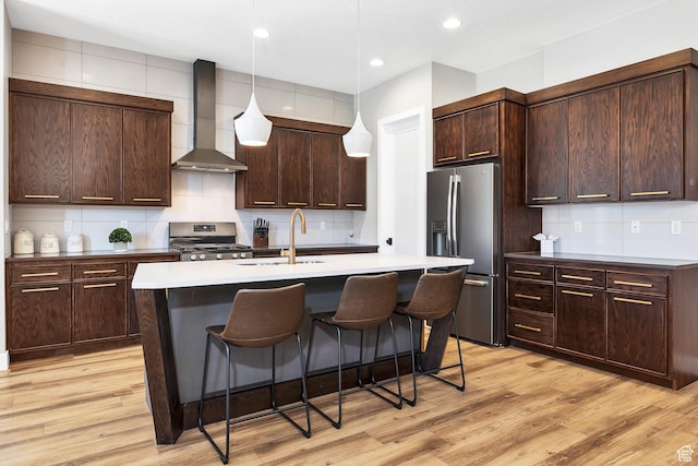 5417 W Copper Cliffs Way, Hurricane, UT 84737 - kitchen featuring a sink, a kitchen breakfast bar, tasteful backsplash, wall chimney range hood, and appliances with stainless steel finishes