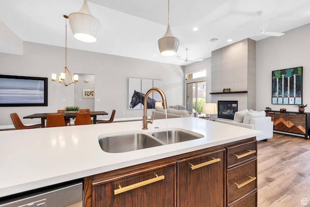 5417 W Copper Cliffs Way, Hurricane, UT 84737 - kitchen with a fireplace, a sink, light countertops, open floor plan, and decorative light fixtures