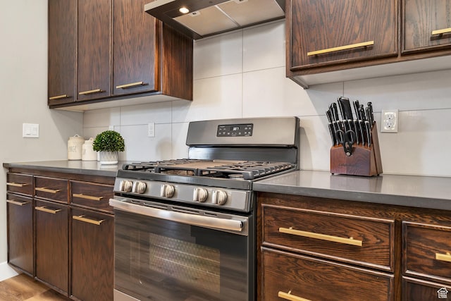 5417 W Copper Cliffs Way, Hurricane, UT 84737 - kitchen featuring dark brown cabinetry, backsplash, dark countertops, stainless steel range with gas stovetop, and premium range hood