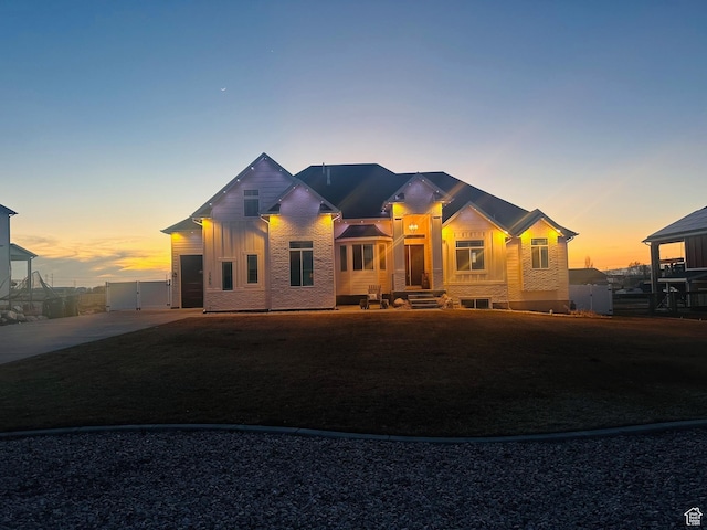view of front of house with concrete driveway, board and batten siding, and a gate