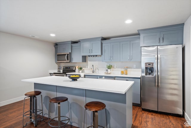 kitchen featuring appliances with stainless steel finishes, dark wood finished floors, and a kitchen bar