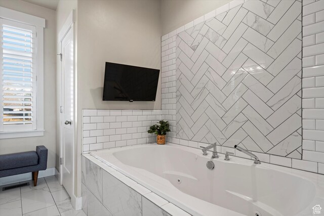 bathroom with marble finish floor, visible vents, baseboards, and a tub with jets