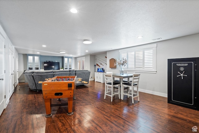 recreation room with a textured ceiling, hardwood / wood-style flooring, recessed lighting, visible vents, and baseboards