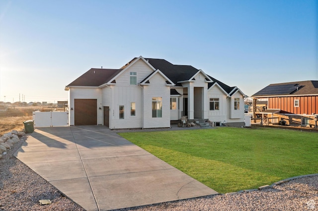 modern inspired farmhouse with an attached garage, fence, concrete driveway, board and batten siding, and a front yard