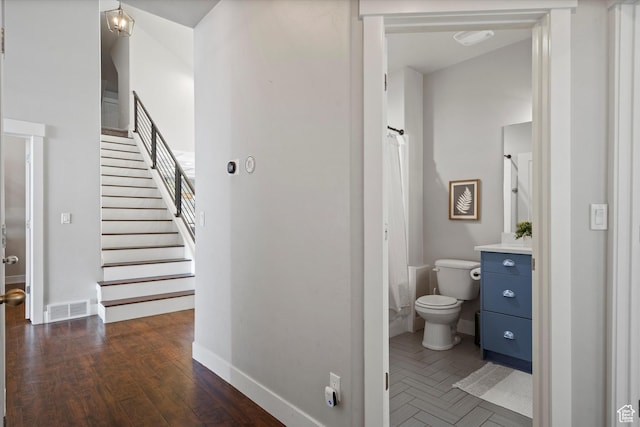 full bath with visible vents, toilet, vanity, wood finished floors, and baseboards