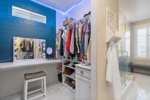 walk in closet with marble finish floor
