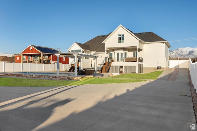 view of front of house with a patio, a fenced backyard, stairway, a front lawn, and a pergola