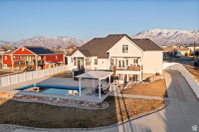exterior space featuring a fenced in pool, a fenced backyard, a mountain view, and a patio