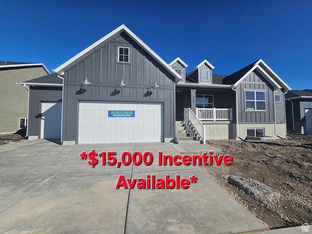 3102 N 2875 W Unit 27, Plain City, UT 84404 - view of front of home featuring board and batten siding, a porch, driveway, and a garage