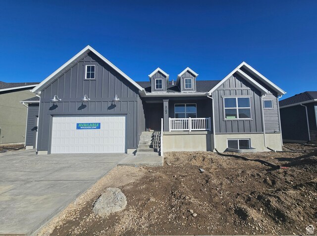 3102 N 2875 W Unit 27, Plain City, UT 84404 - view of front of house with covered porch, concrete driveway, board and batten siding, and an attached garage