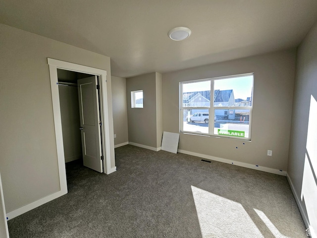 3102 N 2875 W Unit 27, Plain City, UT 84404 - unfurnished bedroom featuring dark colored carpet, a walk in closet, and baseboards