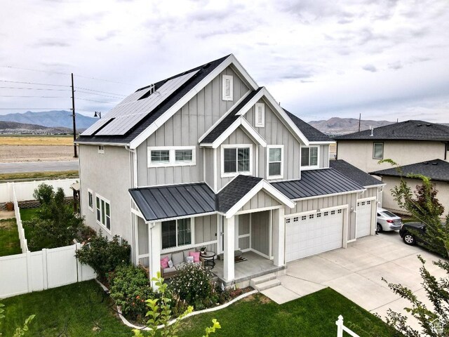 721 S Jubilee Dr, Saratoga Springs, UT 84045 - view of front of home with solar panels, board and batten siding, a standing seam roof, fence, and driveway