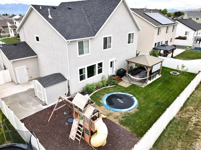 721 S Jubilee Dr, Saratoga Springs, UT 84045 - back of property with a playground, a fenced backyard, a gazebo, a yard, and a trampoline