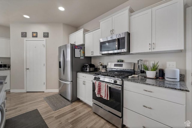 721 S Jubilee Dr, Saratoga Springs, UT 84045 - kitchen featuring dark stone countertops, stainless steel appliances, light wood-type flooring, white cabinetry, and recessed lighting