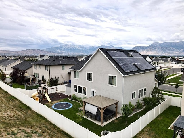 721 S Jubilee Dr, Saratoga Springs, UT 84045 - back of house featuring a playground, a fenced backyard, a mountain view, a gazebo, and roof mounted solar panels