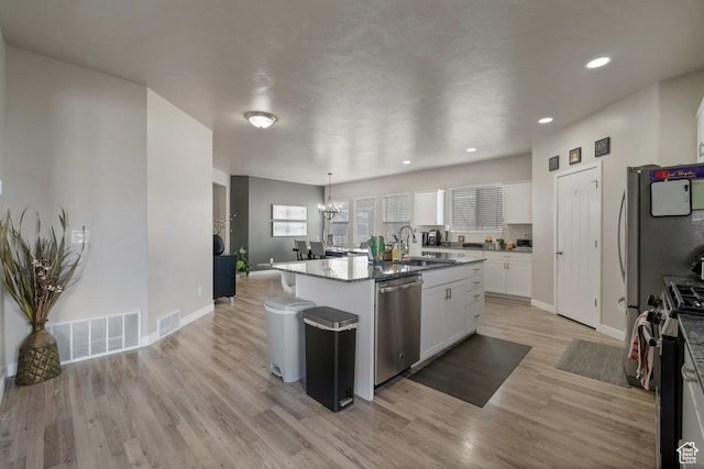 721 S Jubilee Dr, Saratoga Springs, UT 84045 - kitchen with a center island with sink, visible vents, appliances with stainless steel finishes, light wood-style floors, and white cabinetry