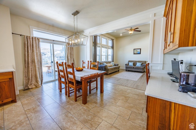 7912 N Secretariat Rd, Eagle Mountain, UT 84005 - dining room with a healthy amount of sunlight, ceiling fan with notable chandelier, and baseboards
