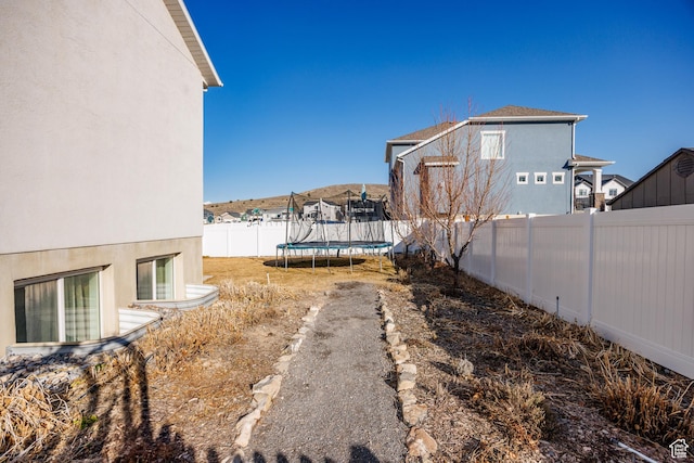7912 N Secretariat Rd, Eagle Mountain, UT 84005 - view of yard with a trampoline and a fenced backyard