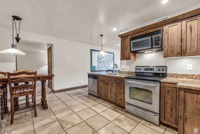 2260 Park Ave Unit 11, Park City, UT 84060 - kitchen with appliances with stainless steel finishes, decorative light fixtures, a sink, and baseboards