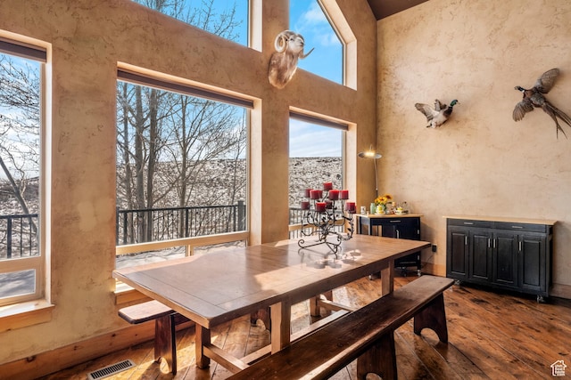 3478 E Porcupine Cir, Garden City, UT 84028 - dining room with visible vents, wood finished floors, and a towering ceiling