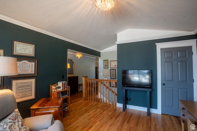 living area with baseboards, vaulted ceiling, wood finished floors, and ornamental molding