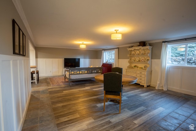 dining area with dark wood-style flooring, crown molding, and wainscoting