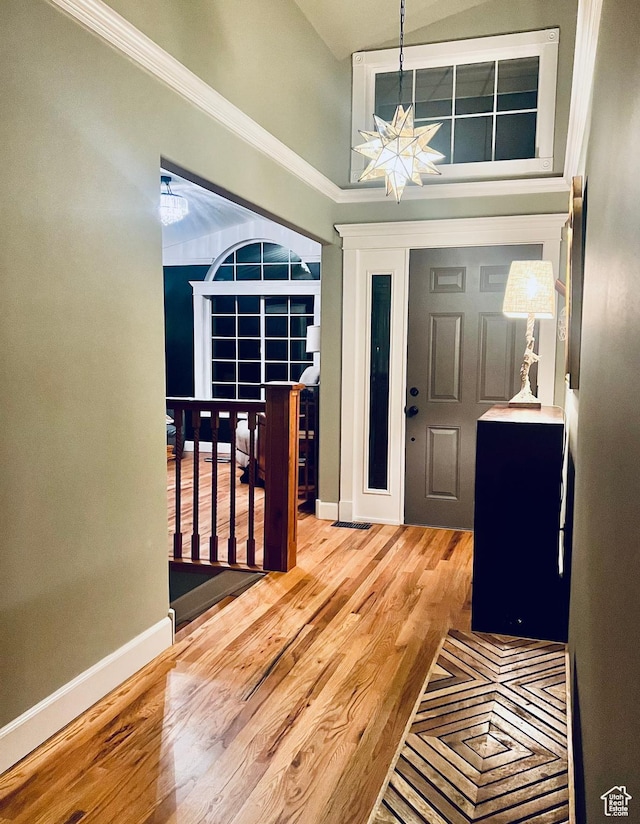 foyer featuring baseboards, a notable chandelier, a high ceiling, and wood finished floors